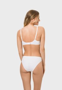 White bikini set featuring a simple design with thin straps and a lined finish, showcasing a smooth texture and classic cut.
