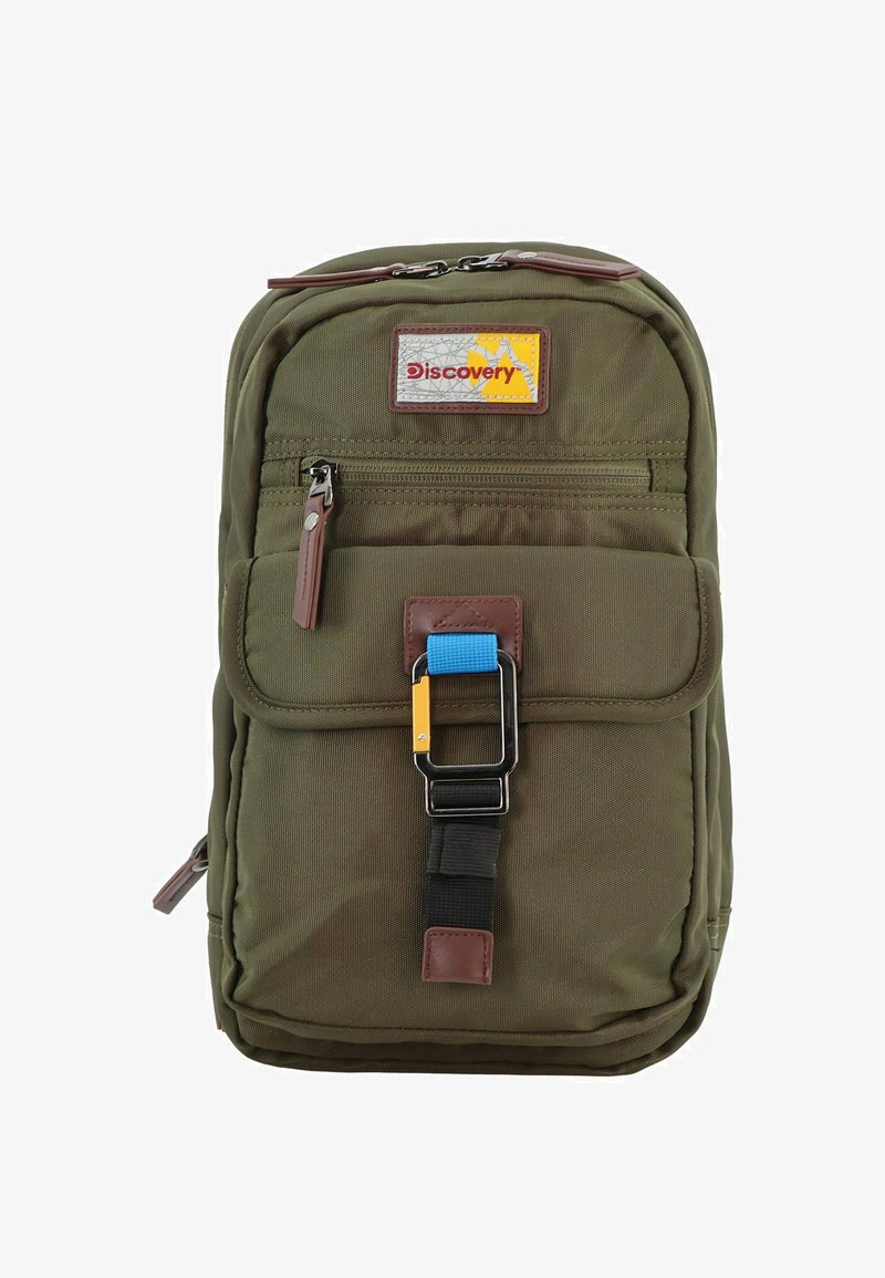 Mochila verde oliva con una tela texturizada, acentos de cuero marrón, bolsillo con solapa en la parte frontal y un detalle de cierre en azul y amarillo.