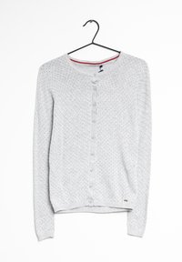 Šedý svetr na knoflíky s kulatým výstřihem, který má vzorovou texturu malých černých teček a malou visačku s logem na spodním lemu.