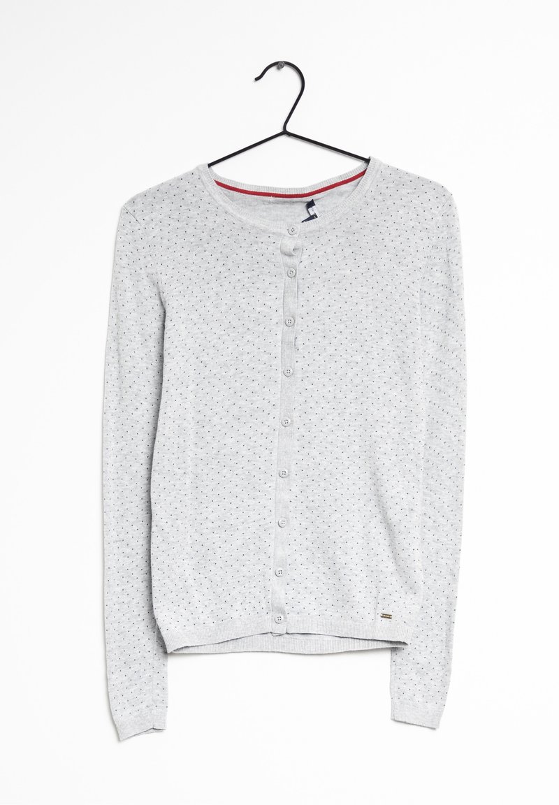 Šedý svetr na knoflíky s kulatým výstřihem, který má vzorovou texturu malých černých teček a malou visačku s logem na spodním lemu.