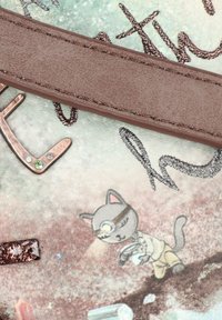 Wielokolorowa torba z gładką fakturą, brązowym paskiem i grafiką kota z latarką na tle lśniącej powierzchni.