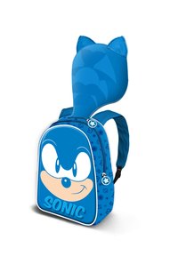 Sac à dos bleu présentant le visage de Sonic le hérisson, avec des oreilles en peluche sur le dessus, une texture lisse, une fermeture éclair et un petit tirette en forme d'étoile.