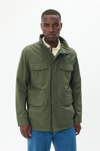 Olivegrüne, leichte Jacke mit hohem Kragen, vier Fronttaschen und Reißverschluss. Glatte Textur, minimalistisches Design.