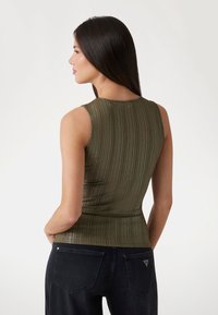 Olive green sleeveless top with a ribbed texture and fitted design, featuring a round neckline and slightly cropped silhouette.