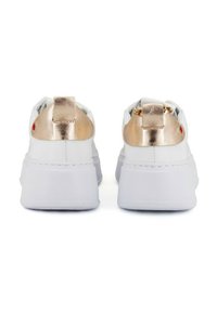 Un paio di sneaker bianche con platform, dotate di elementi metallici color rosa oro sul tallone e di linguette per il sollevamento, viste da dietro su uno sfondo bianco.