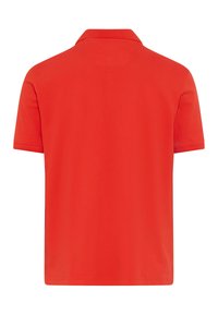 Chemise polo rouge avec un col classique, des manches courtes et une texture lisse. Le dos est uni sans motifs ni détails.