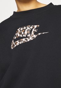 Zwarte sweatshirt met een luipaardenprint Nike-logo. De halslijn is van het crew-stijl, met een gladde, zachte stofstructuur.