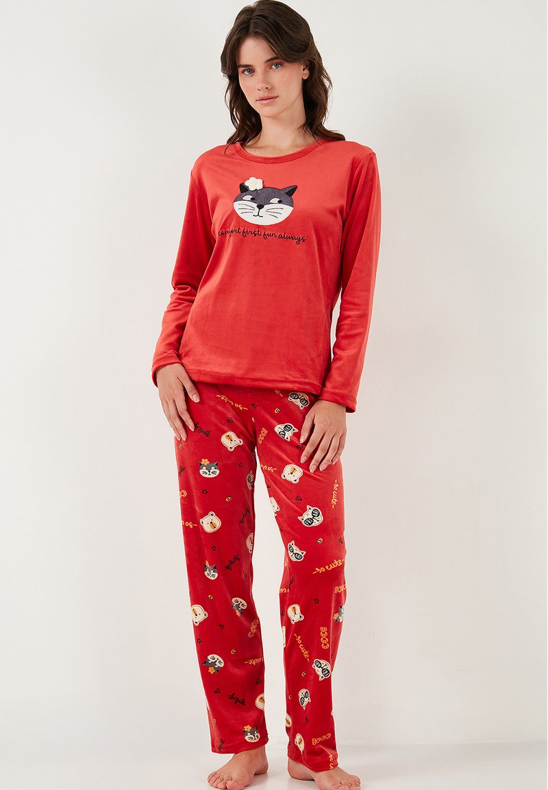 Roter Velour-Pyjama-Set mit einem Langarmoberteil, das ein Katzen-Gesichtdesign und Text aufweist, kombiniert mit gemusterten Hosen, die verschiedene Tiergesichter zeigen.