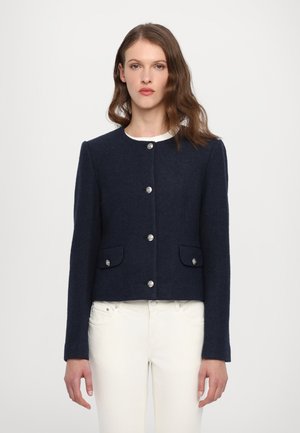 Chaqueta de mezcla de lana azul marino con cuello redondo, botones plateados y bolsillos frontales. Corte ajustado con una textura suave.