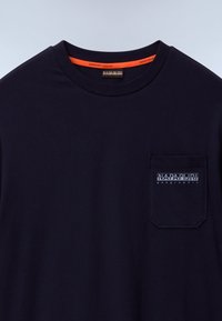 Navy blue cotton t-shirt with a round neckline, featuring a chest pocket adorned with a white logo. Smooth texture, relaxed fit.