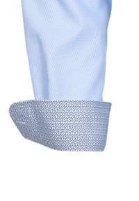 Polsino di camicia azzurra chiara, caratterizzato da una finitura testurizzata e un bordo con un motivo a contrasto in blu navy e bianco.