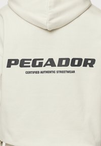 Pegador Jersey con capucha - beige