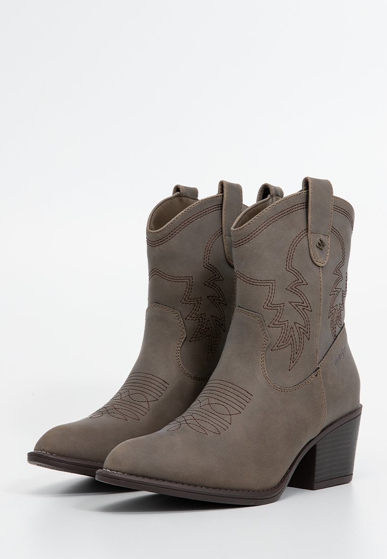 Botas de vaquero de cuero marrón con punta afilada, costuras grabadas y lengüetas de tirón. Tacón cuadrado con suela de goma texturizada.