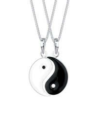 Zilveren ketting met een yin-yang hanger. De hanger is half wit en half zwart met kleine cirkelvormige accenten aan elke zijde.
