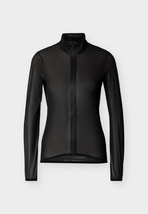 Melna viegla jaciņa ar garām piedurknēm, pilnu priekšējo rāvējslēdzēju, augstu apkakli un piegulošu siluetu uz vienmērīga balta fona.