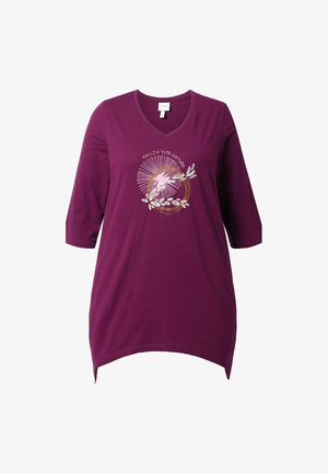 Lila Tunika mit V-Ausschnitt, drei Viertelärmeln und abgerundetem Saum. Sie weist ein florales und textliches Design in Weiß und Gold auf der Vorderseite auf.