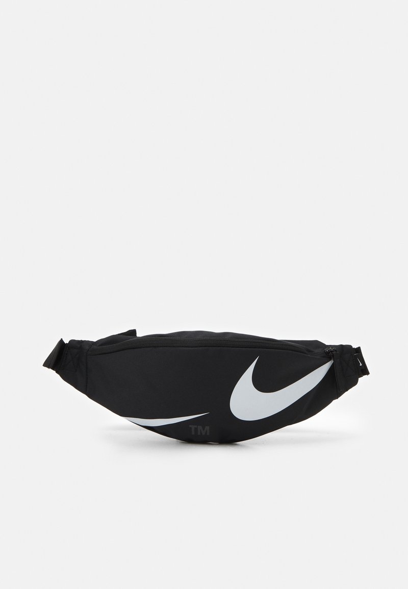 Svart midjeväska i slitstarkt tyg, med en stor vit Nike swoosh-logga och justerbar rem, dragkedjestängning på toppen.