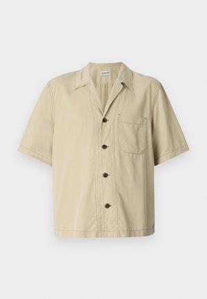 Short-sleeve beige shirt made of cotton with a pointed collar, button closure, and left chest pocket. Smooth texture, simple design.