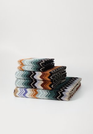 Set of four towels with a zigzag pattern in teal, orange, black, brown, and lavender. Each towel is neatly folded and stacked.
