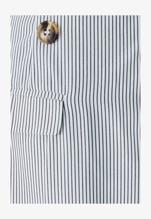 Raidallinen kangas valkoisena ja mustana, jossa on yksi paikallaan oleva tasku ja pyöreä, vaaleanruskea nappi, jossa on kaksi reikää.