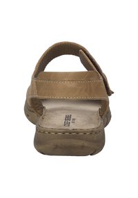 Brązowe skórzane sandały z tylnym paskiem, antypoślizgową podeszwą i wyściełaną wkładką. Posiadają teksturowaną powierzchnię oraz proste przeszycia.