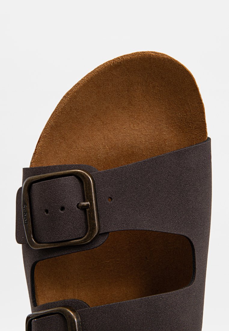 Sandales marron et noires avec un design à bout ouvert, dotées d'une large sangle et d'une boucle en métal ajustable pour la fermeture. Semelle intérieure texturée.