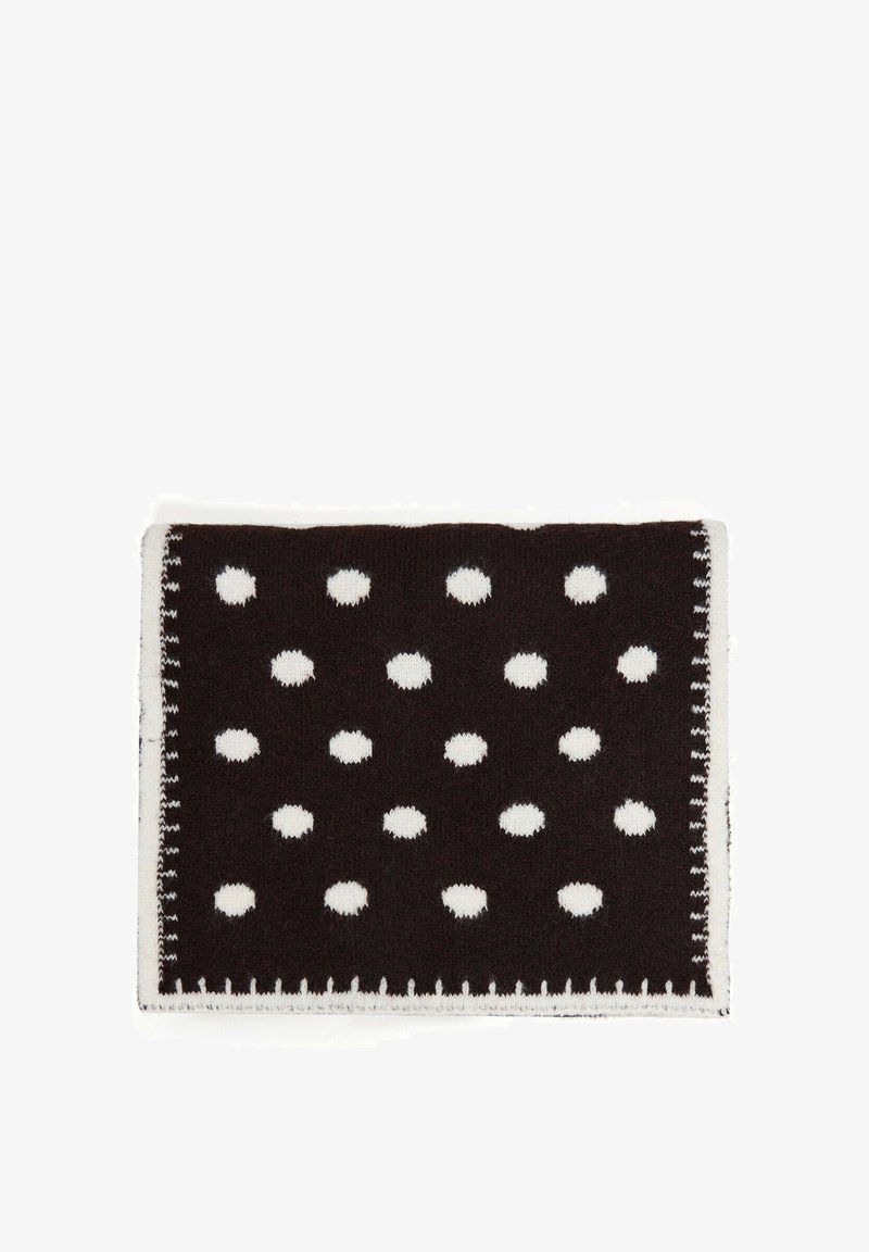 Couverture rectangulaire en tricot noire avec des pois blancs espacés uniformément et une bordure blanche cousue sur un fond blanc.