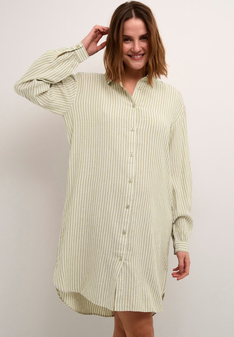 Robe chemise à rayures vert clair et blanches avec des manches longues, un ourlet arrondi et une coupe décontractée, fabriquée dans un tissu léger.