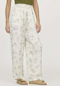 Pantalons légers de couleur crème avec des motifs floraux. Comprend une taille élastique et des jambes larges et fluides. Tissu doux avec une texture lisse.