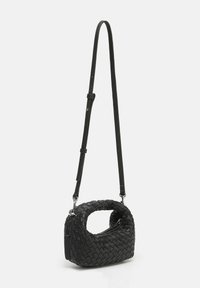 Sac à main en cuir tressé noir avec une poignée courbée, une sangle détachable et une surface texturée. Design compact avec une forme rectangulaire.
