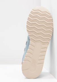 Niebieskie zamszowe trampki z teksturowaną jasnobeżową gumową podeszwą, z charakterystycznym wzorem zygzakowym i subtelnym logo po boku.