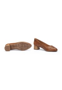 Escarpins en cuir couleur tan avec un design perforé, bout rond et talon bloc. Semelle en caoutchouc avec un motif pour une meilleure adhérence.
