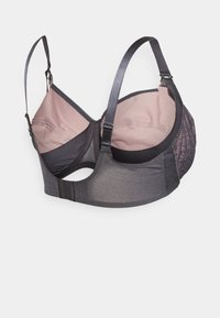 Reggiseno nero e rosa con spalline regolabili, dettagli testurizzati su una coppa e chiusura a gancio sul retro. Tessuto morbido e supporto con ferretto.