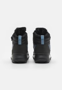 Pár černých a modrých zimních bot s texturovanou podrážkou a modrými poutky, z pohledu zezadu na bílém pozadí.