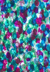 Mehrfarbiger Glitzer mit türkisfarbenen, grünen, rosa und silbernen Punkten, einige mit einem strukturierten Muster, auf einem reflektierenden Hintergrund.