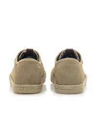 Scarpe in suède beige con una finitura testurizzata, con suola in corda e un accento marrone sul tallone. Foderate con un interno in tessuto decorato.