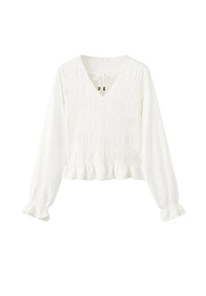 Hvid bluse med lange ærmer, V-udskæring, smocket tekstur, indsamlede manchetter og en flæsekant. Har bindelukning ved halsudskæringen.