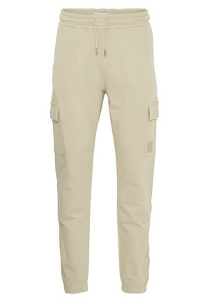 Pantalon cargo en coton beige avec taille élastique, cordon de serrage ajustable, poches latérales et design fuselé.