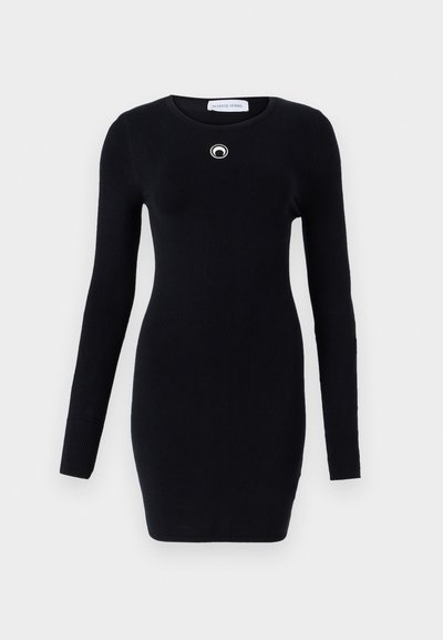Rochie tricotată neagră cu guler rotund și mâneci lungi. Are un accent circular argintiu pe piept. Textură netedă și formă ajustată.