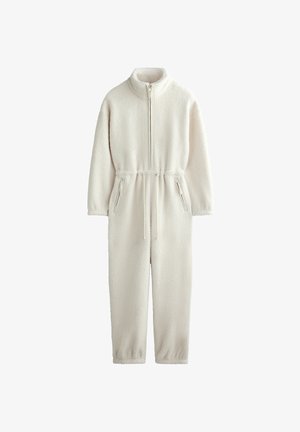 Kombinezon z polaru w kolorze ecru, z wysokim kołnierzem, przednim zamkiem błyskawicznym, regulowanym sznurkiem w talii oraz kieszeniami bocznymi na zamek dla funkcjonalności.