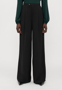 Zwarte, high-waisted wijde broek met plooien aan de voorkant, een enkele knoopsluiting en een gladde, gestructureerde stof.