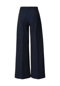 Tumši zili plaša piegriezuma bikses ar gludu tekstūru. Ar aizmugures vīli un divām aizmugures kabatām. Izšūts piegriezums ar tīru, minimālistisku dizainu.