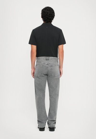 Zwarte kortemouw polo, gecombineerd met hoog-waist grijze denim jeans. De jeans hebben een klassieke vijf-pocket stijl en een recht gesneden pasvorm.