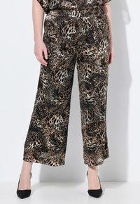 Leopardprint wijde broek in bruine en zwarte tinten met een glanzende textuur en een elastische tailleband. Gecombineerd met zwarte hakken.