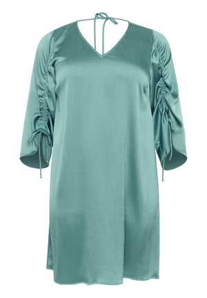 Mėlynos satino suknelė su V formos iškirpte ir surišamomis petnešėlėmis. Yra raukšlėtos rankovės su reguliuojamomis rišimo detalėmis, tiesus apatinis kraštas ir lengvas audinys.