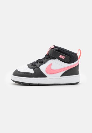 Schwarz-weißes High-Top-Sneaker mit pinken Akzenten, ausgestattet mit Schnürung und Klettverschluss, strukturiertem Obermaterial und Gummisohle.