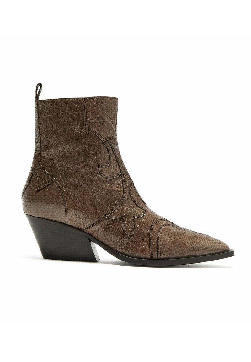 Stivaletto alla caviglia in pelle marrone con punta appuntita, superficie testurizzata, cuciture decorative e tacco angolare di altezza media.