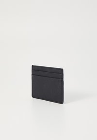 Porta-cartões preto feito de material texturizado. Apresenta quatro bolsos tipo slot e um design slim para fácil transporte.