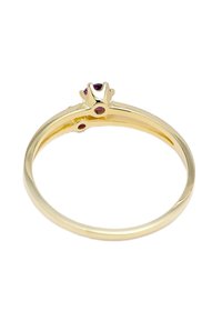 Guldring med en upphöjd inställning som har en central röd ädelsten och två mindre röda stenar på banden; slät, polerad yta.