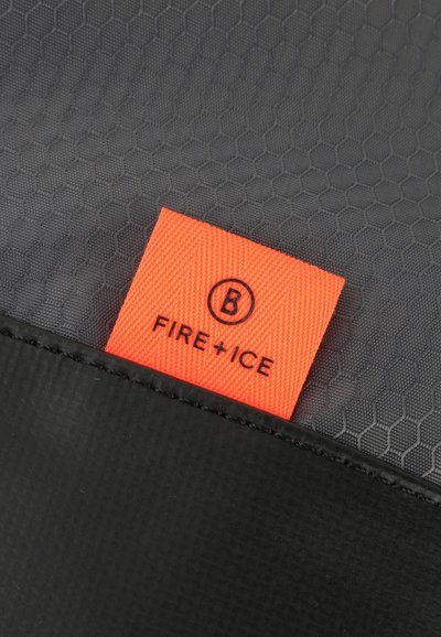 Tessuto nero testurizzato con un motivo esagonale, caratterizzato da un'etichetta arancione con la scritta "FIRE+ICE" e un logo. Cuciture nere sottili.